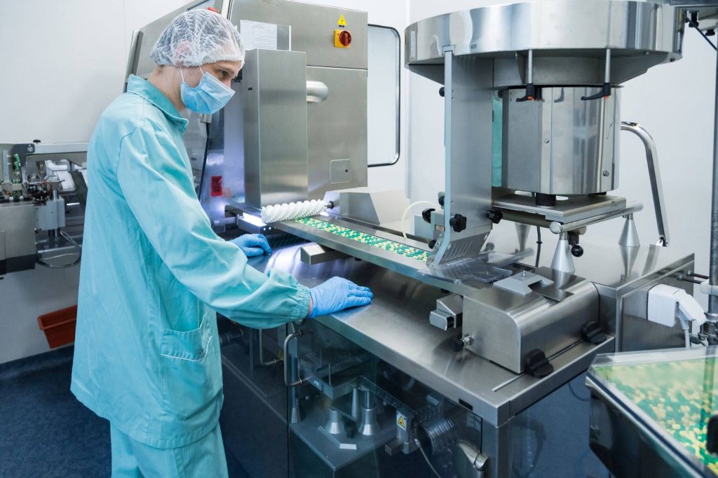 pharmaceutical technician operating a tablet packaging machine